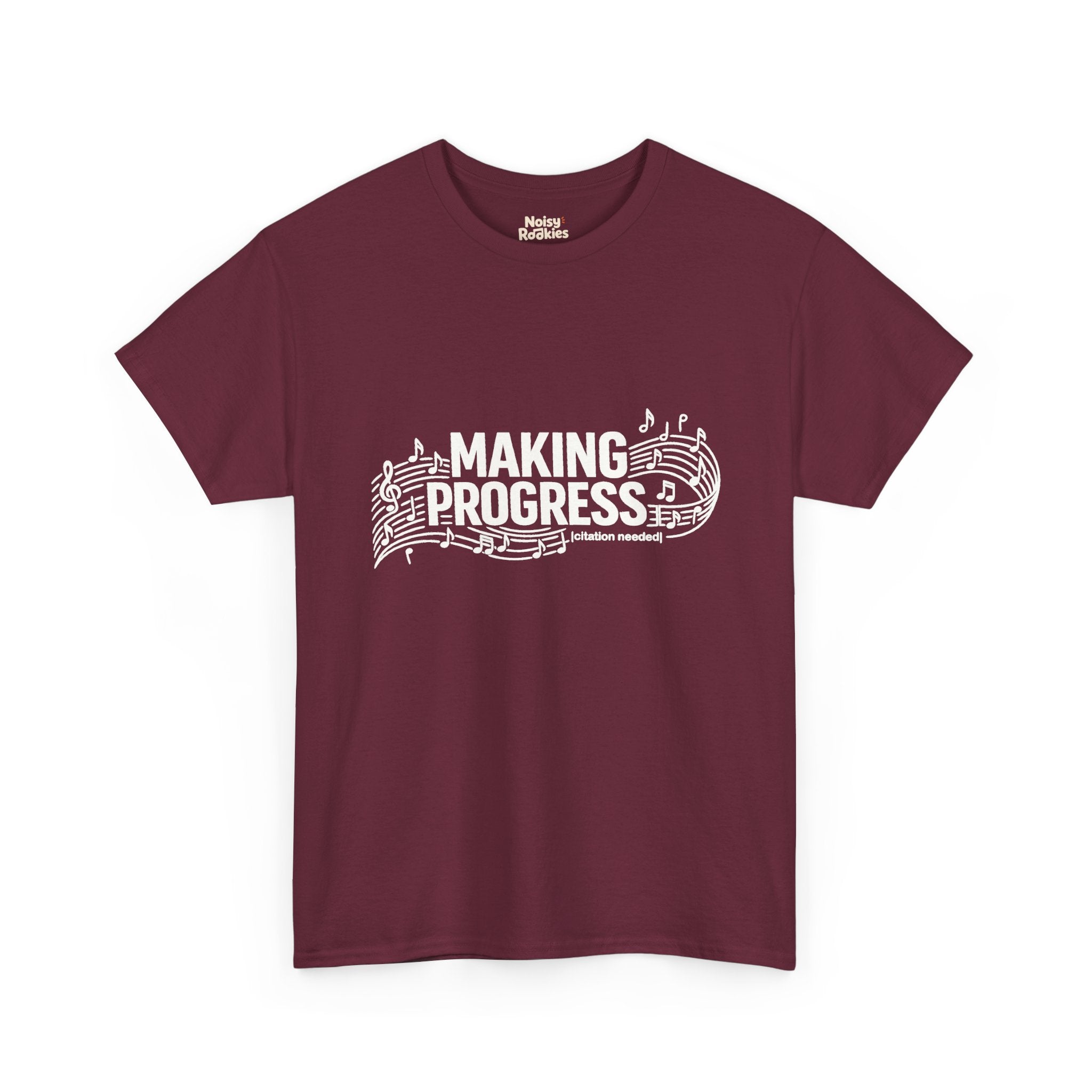 White t-shirt design reading MAKING PROGRESS with a small "citation needed" tag, woven through a flowing musical staff with a treble clef and scattered notes.