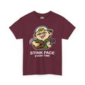 The same cartoon kid strumming a ukulele with the concentration grimace, outlined in a white keyline so the black linework lifts off a dark shirt. White caption beneath reads STINK FACE on the first line and EVERY TIME on the second.