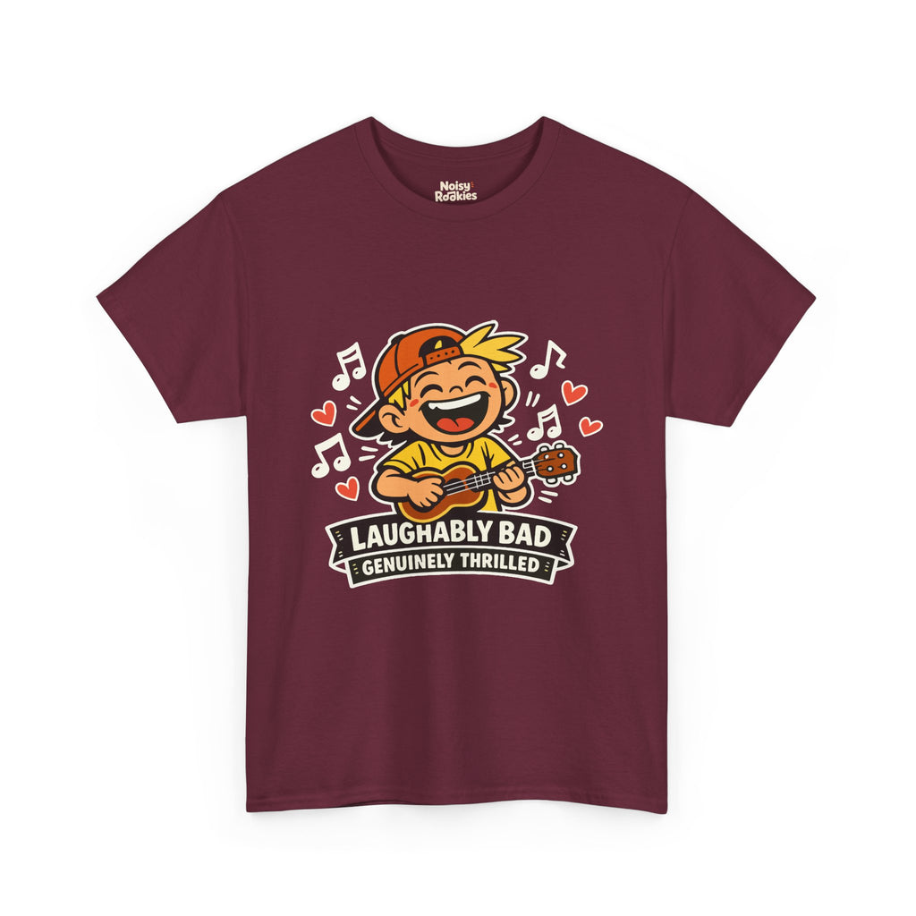 Dark-shirt design of a beaming cartoon kid in a backward cap strumming a ukulele, surrounded by music notes and hearts, over a banner reading Laughably Bad Genuinely Thrilled.